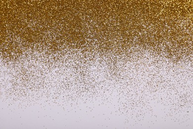 Shiny golden glitter on white background, top view