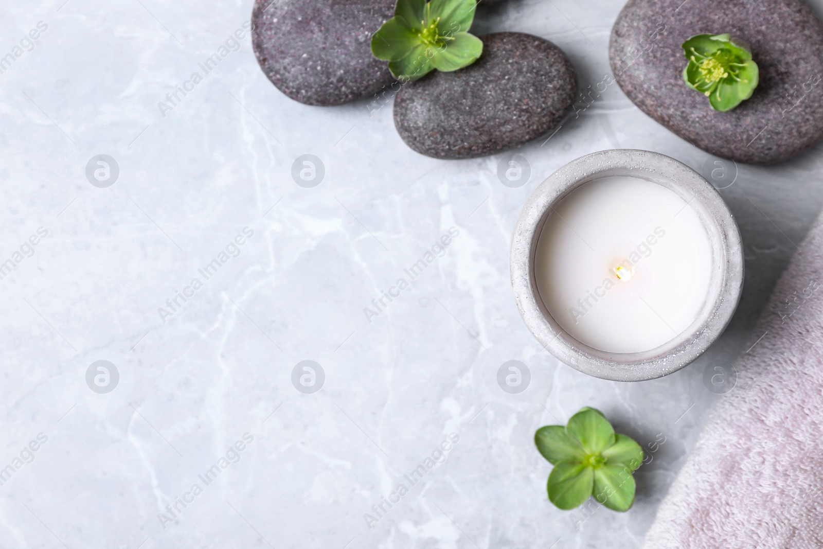 Photo of Flat lay composition with spa stones and burning candle on grey marble table, space for text