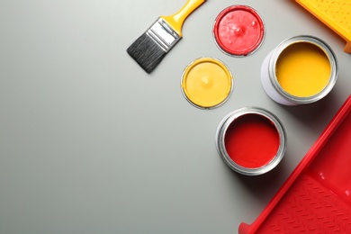 Photo of Flat lay composition with paint cans and brush on grey background. Space for text
