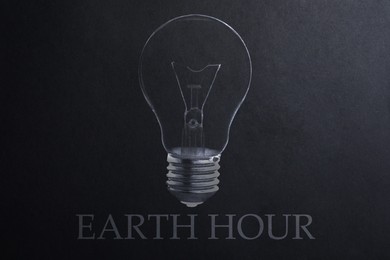 Image of Earth hour concept. Drawing of light bulb on black paper