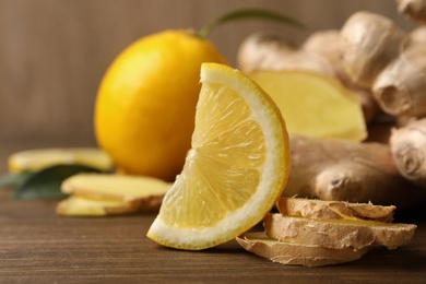 Photo of Fresh lemon and ginger on wooden table, closeup