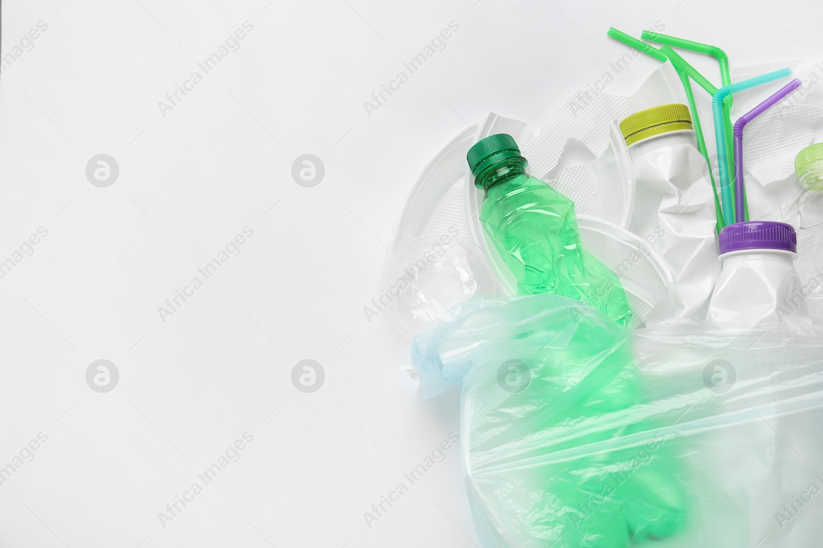 Photo of Pile of different plastic items on white background, flat lay. Space for text