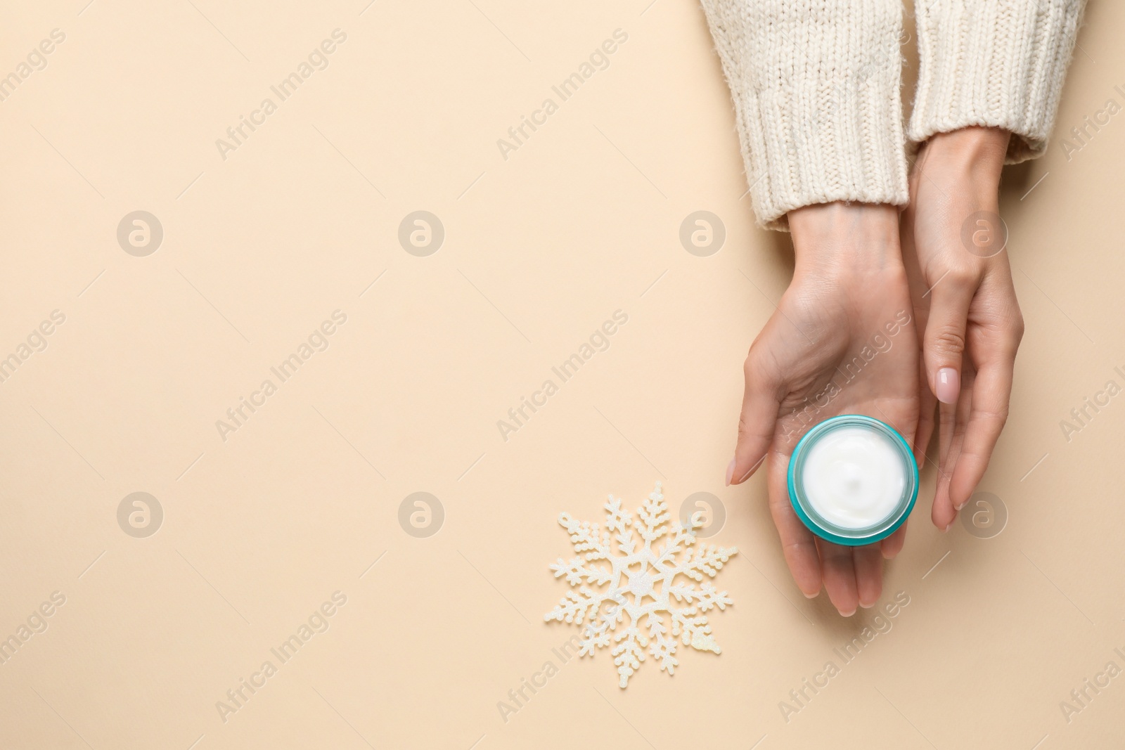 Photo of Woman with jar of hand cream on beige background, top view. Space for text