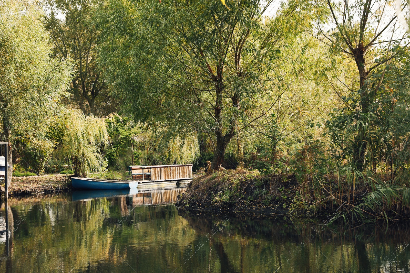 Photo of Beautiful view of autumn river with light blue wooden boat