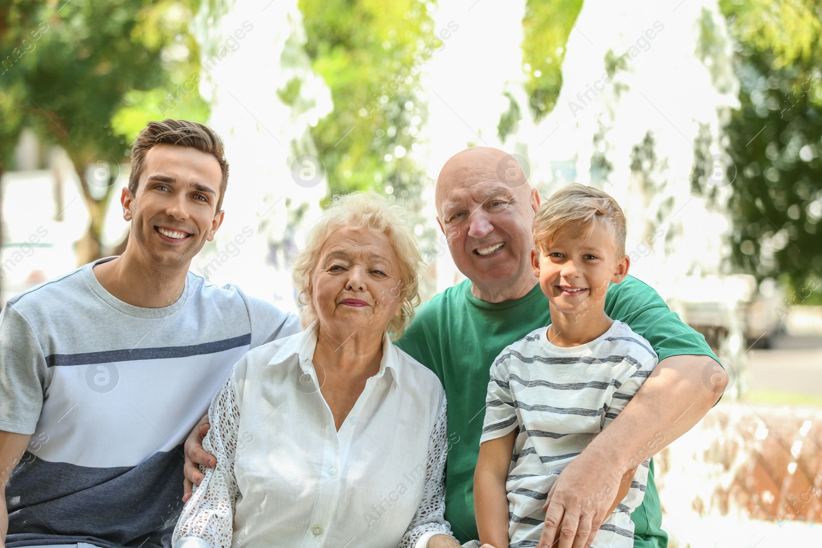 Photo of Man with son and elderly parents outdoors