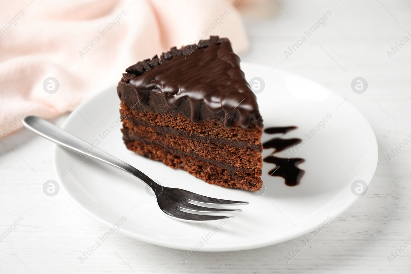 Photo of Tasty chocolate cake served on white wooden table