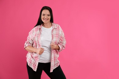 Photo of Beautiful overweight woman with charming smile on pink background. Space for text