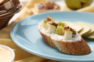 Photo of Delicious ricotta bruschetta with pear and walnut served on table, closeup