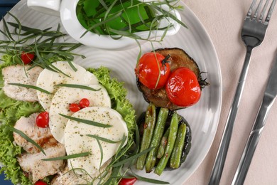 Photo of Tasty mozzarella, chicken and vegetables with tarragon served on table, flat lay