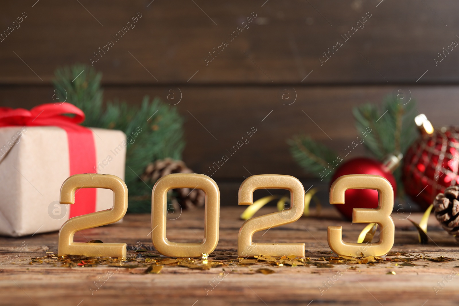 Photo of Number 2023 and festive decor on wooden table, space for text. Happy New Year