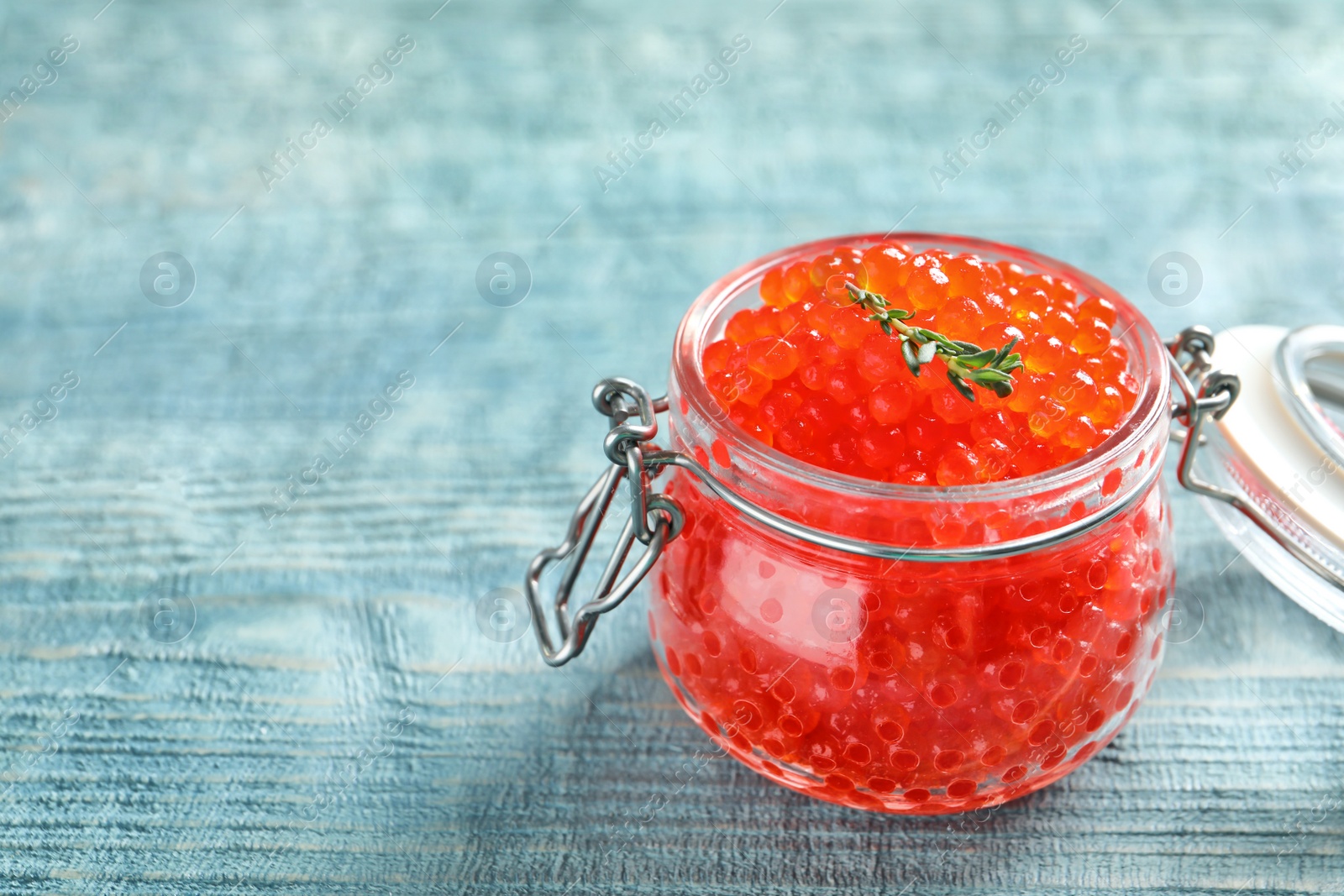 Photo of Glass jar with delicious red caviar on table