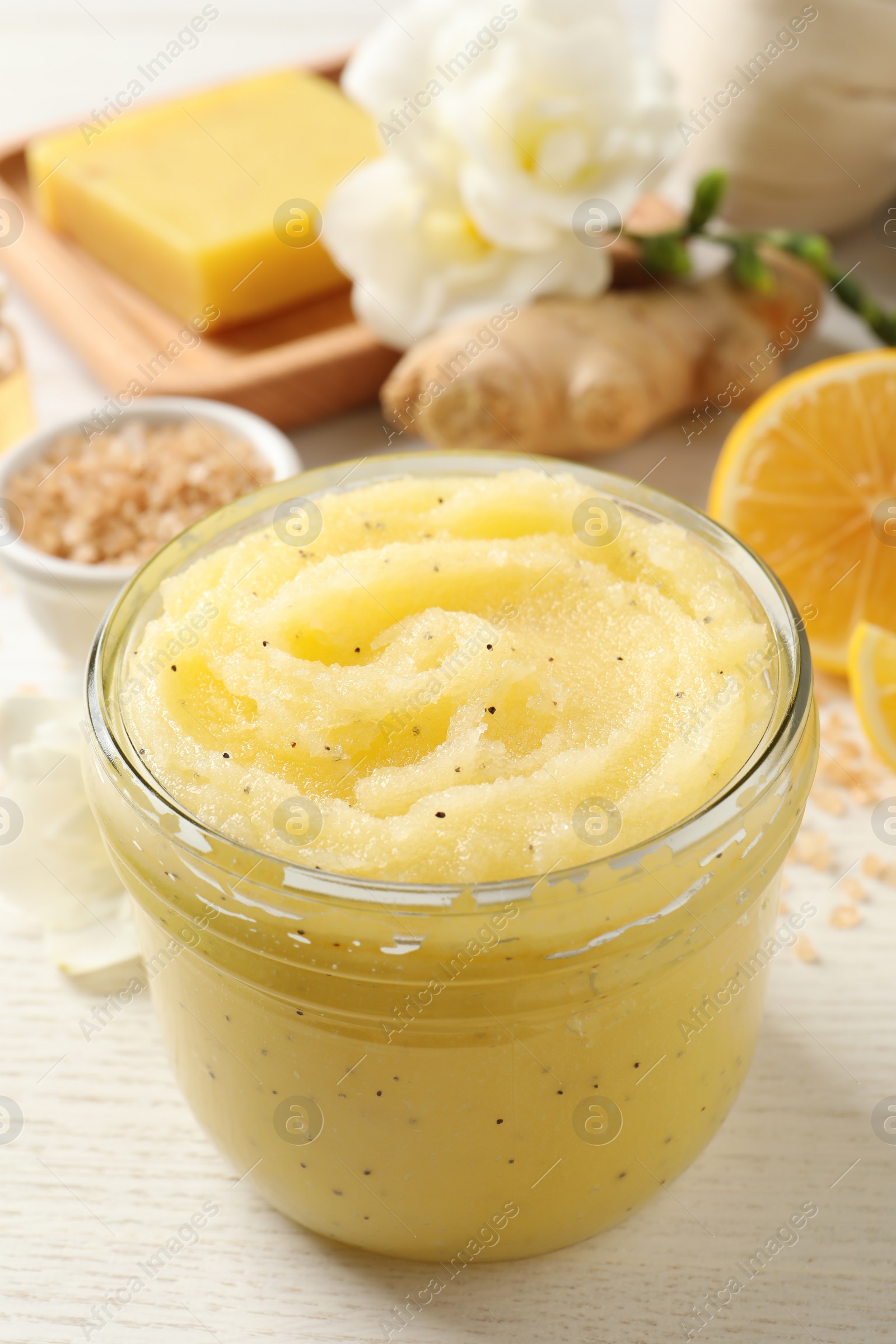 Photo of Body scrub in glass jar on white wooden table, closeup