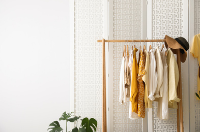 Photo of Rack with stylish women's clothes indoors. Interior design