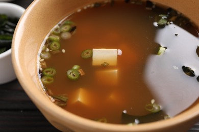 Bowl of delicious miso soup with tofu on table, closeup
