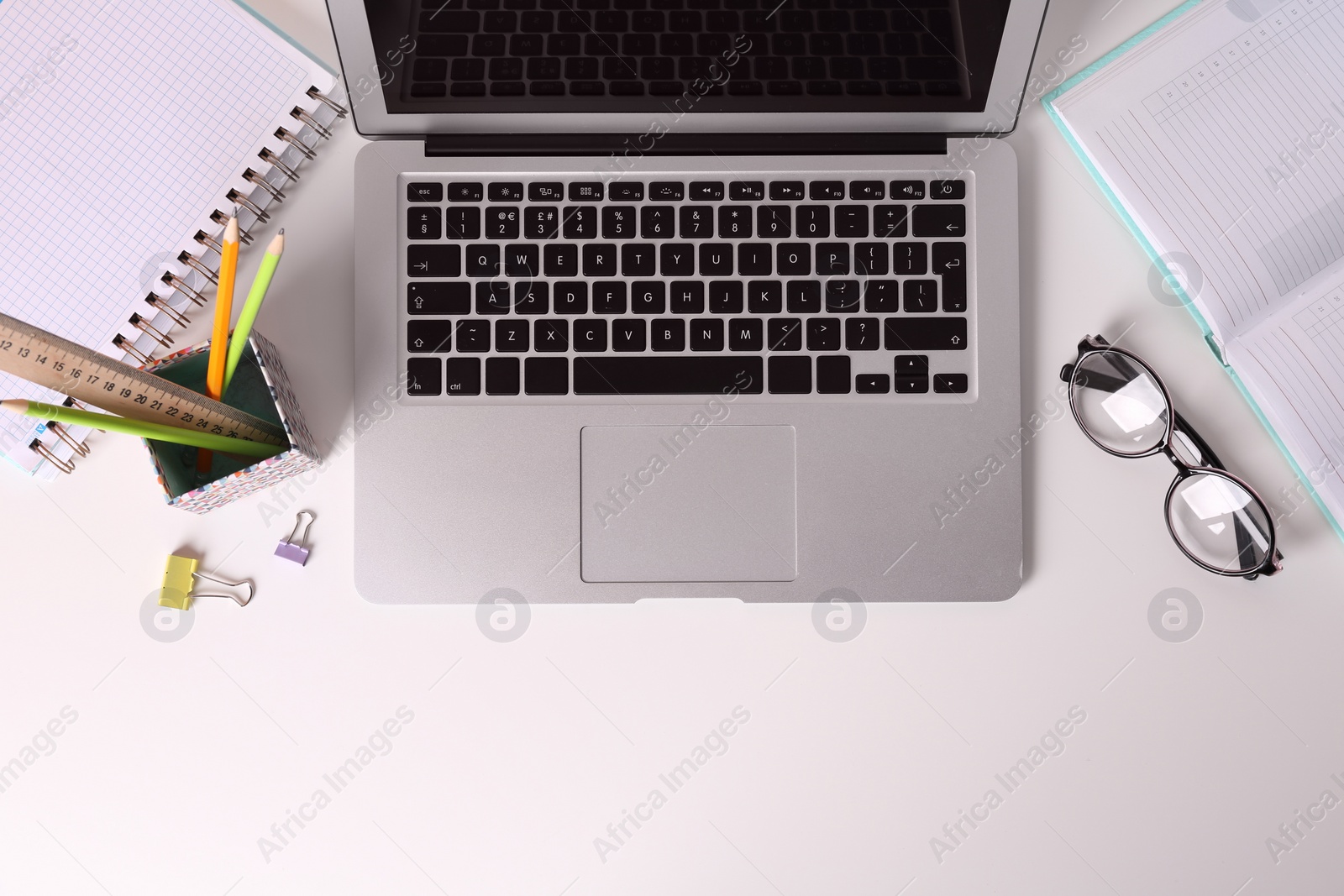 Photo of Flat lay composition with laptop and stationery on office table