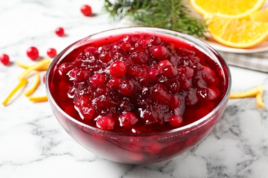 Photo of Bowl of cranberry sauce on white marble table