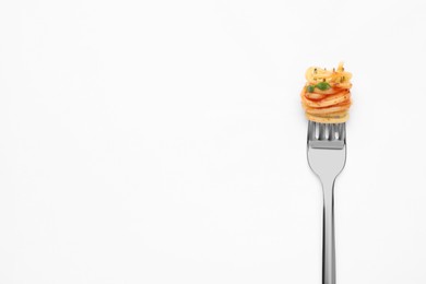 Photo of Fork with tasty pasta on white background, top view. Space for text