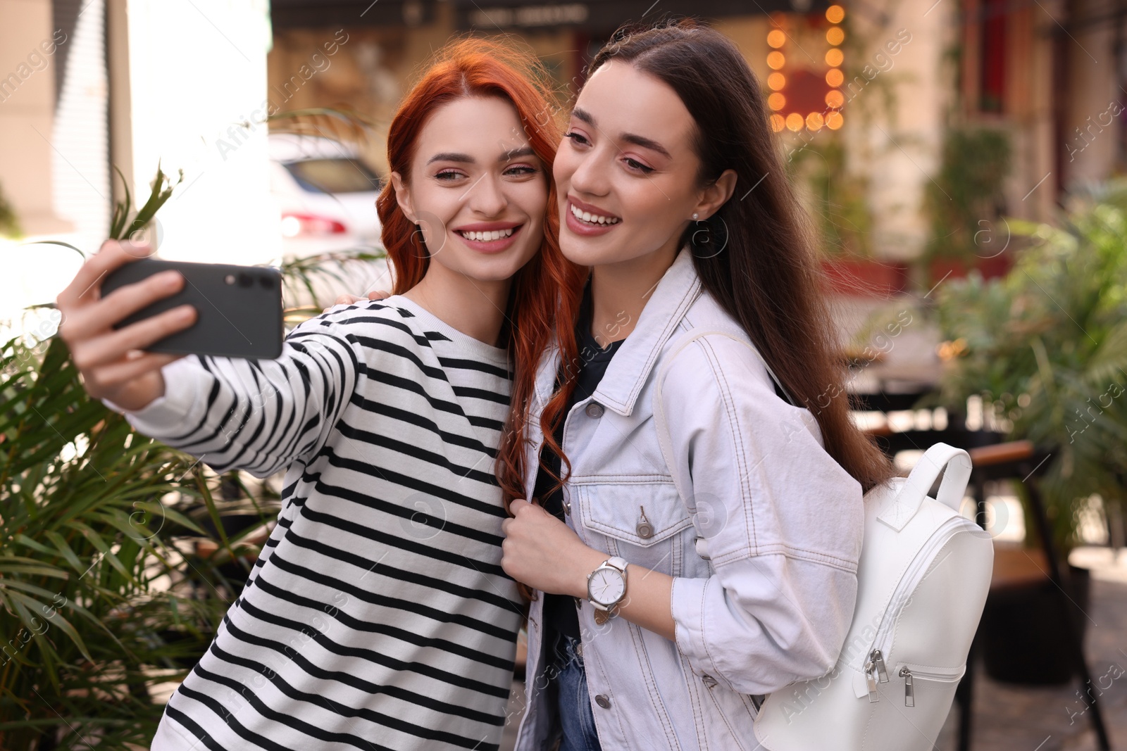 Photo of Happy friends taking selfie outdoors on autumn day