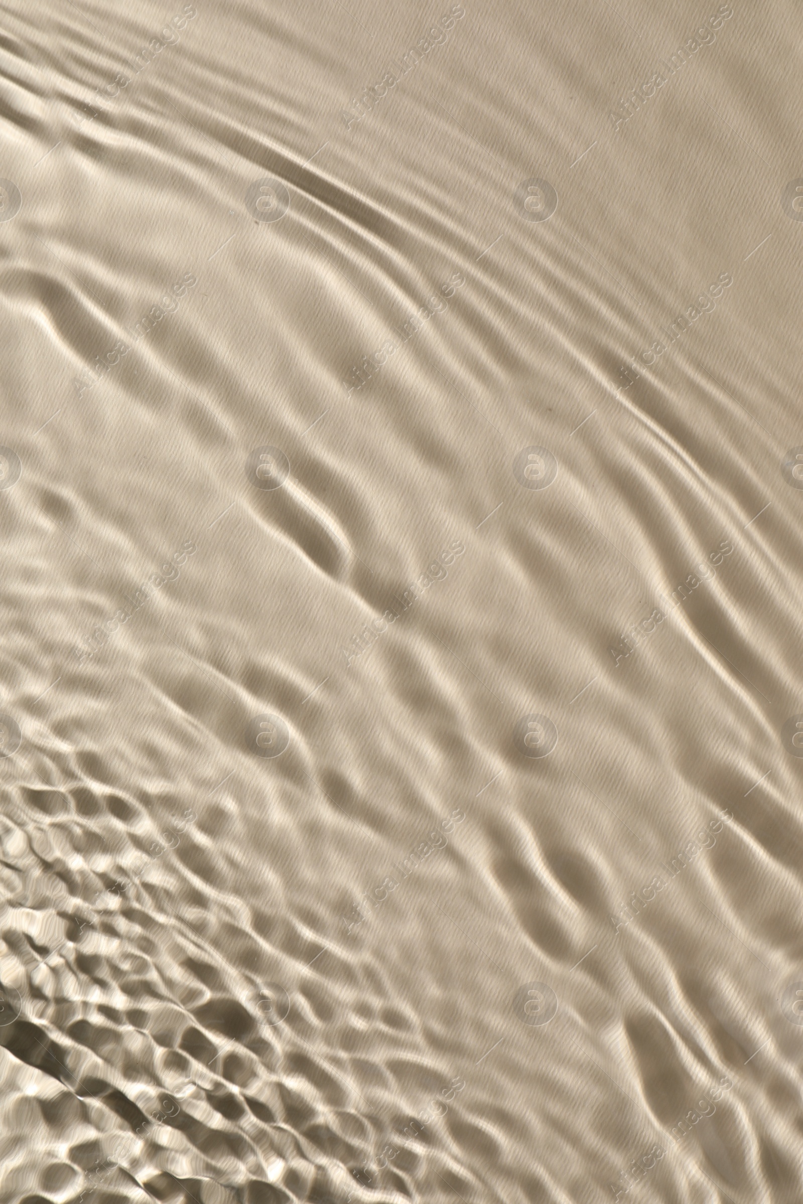 Photo of Rippled surface of clear water on beige background, top view