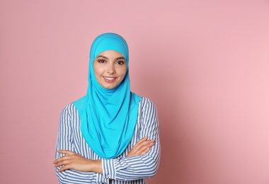 Photo of Portrait of young Muslim woman in hijab against color background