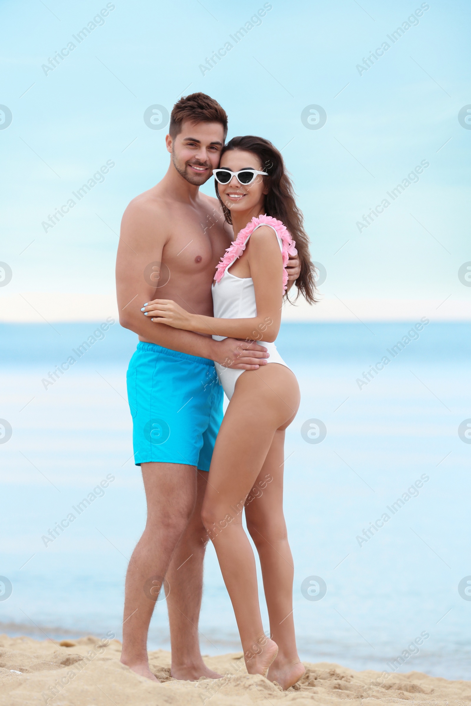 Photo of Happy young couple spending time together on beach near sea