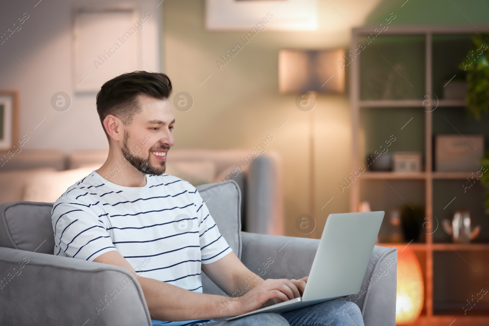 Photo of Young man using laptop at home