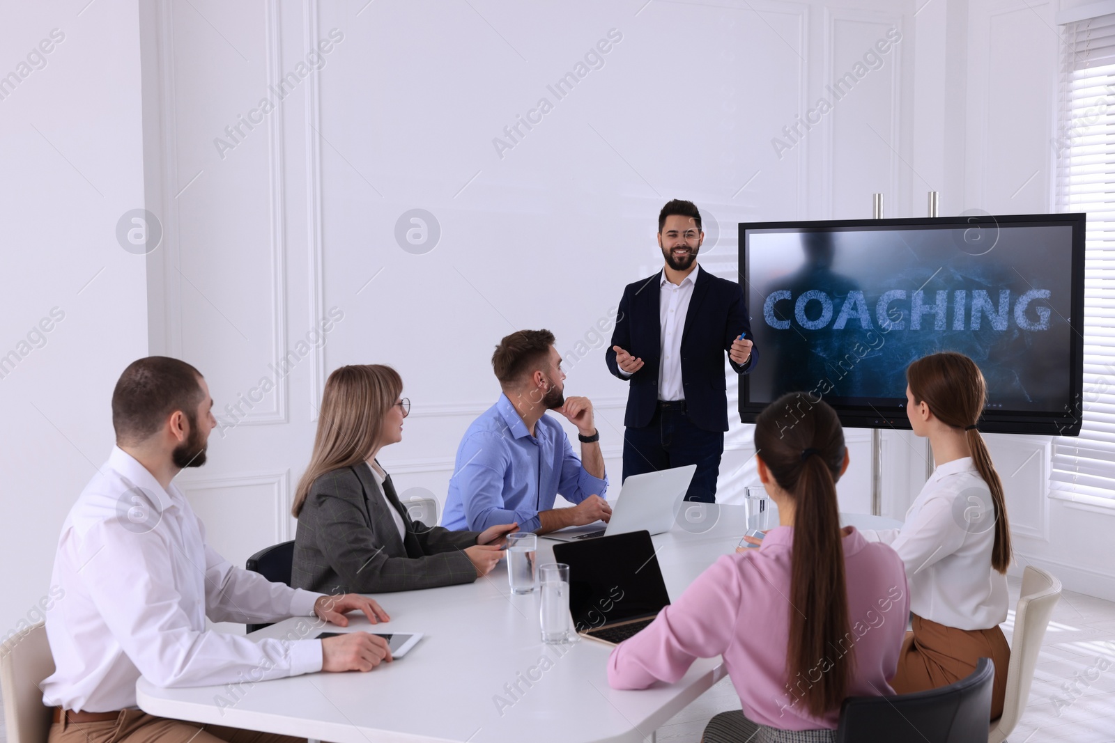 Photo of Business trainer near interactive board in meeting room during presentation