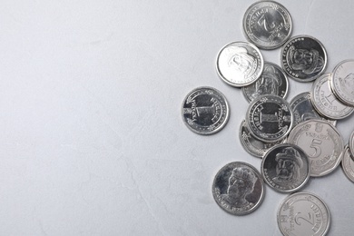 Photo of Ukrainian coins on grey background, flat lay. Space for text