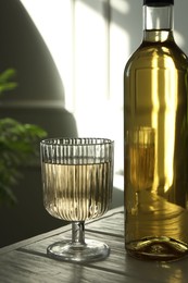 Photo of Alcohol drink in glass and bottle on wooden table indoors, closeup