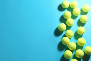 Tennis balls on blue background, flat lay. Space for text