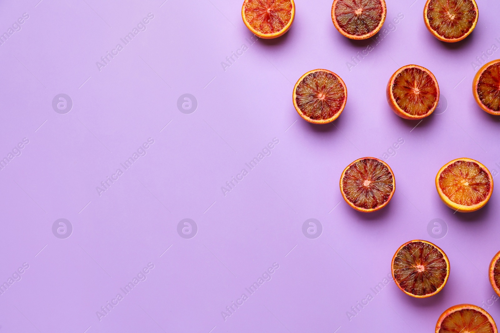 Photo of Many ripe sicilian oranges on violet background, flat lay. Space for text