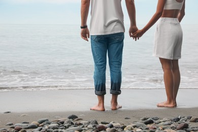 Photo of Young couple on beach near sea, closeup. Space for text