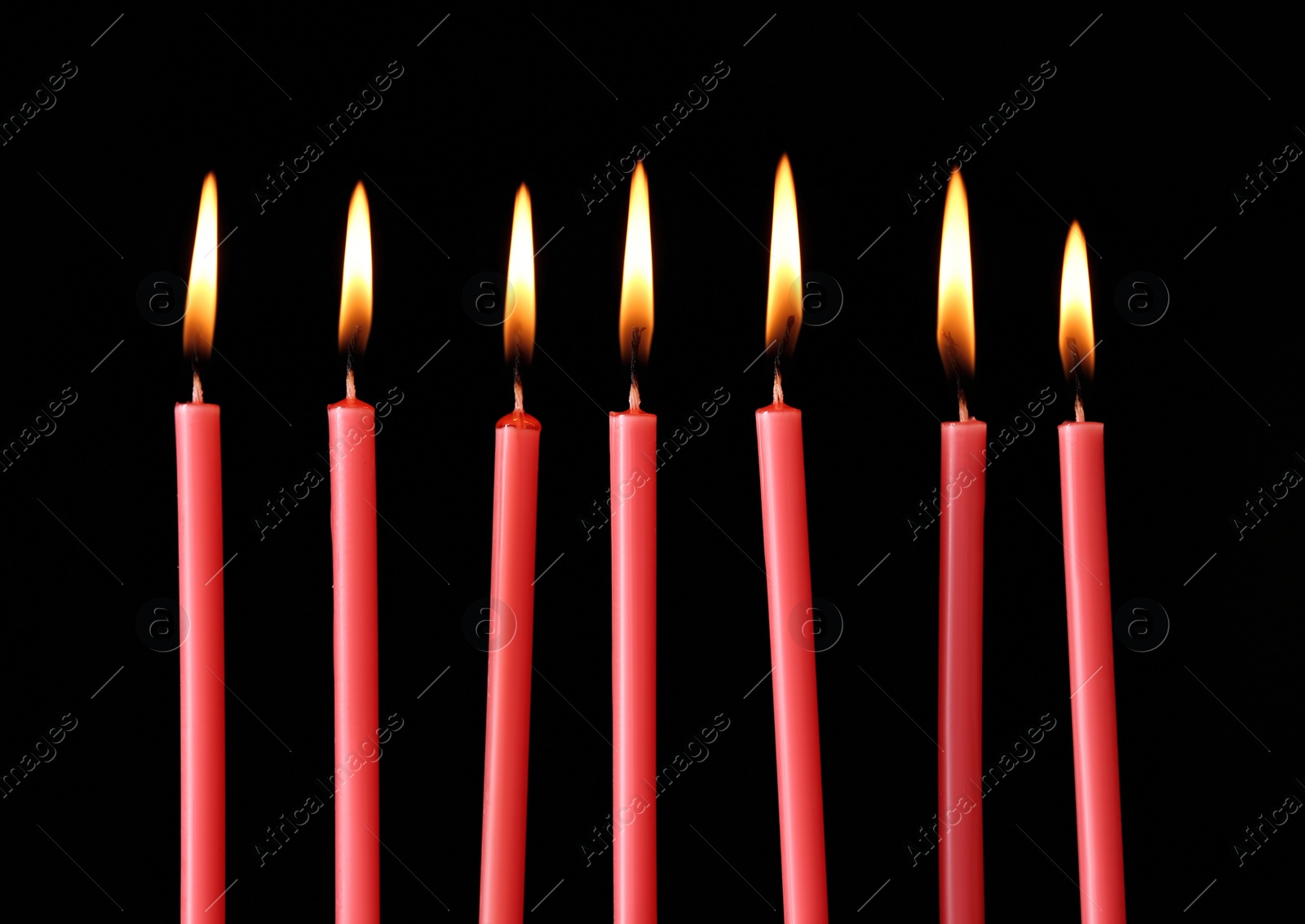Photo of Burning red candles on black background, closeup