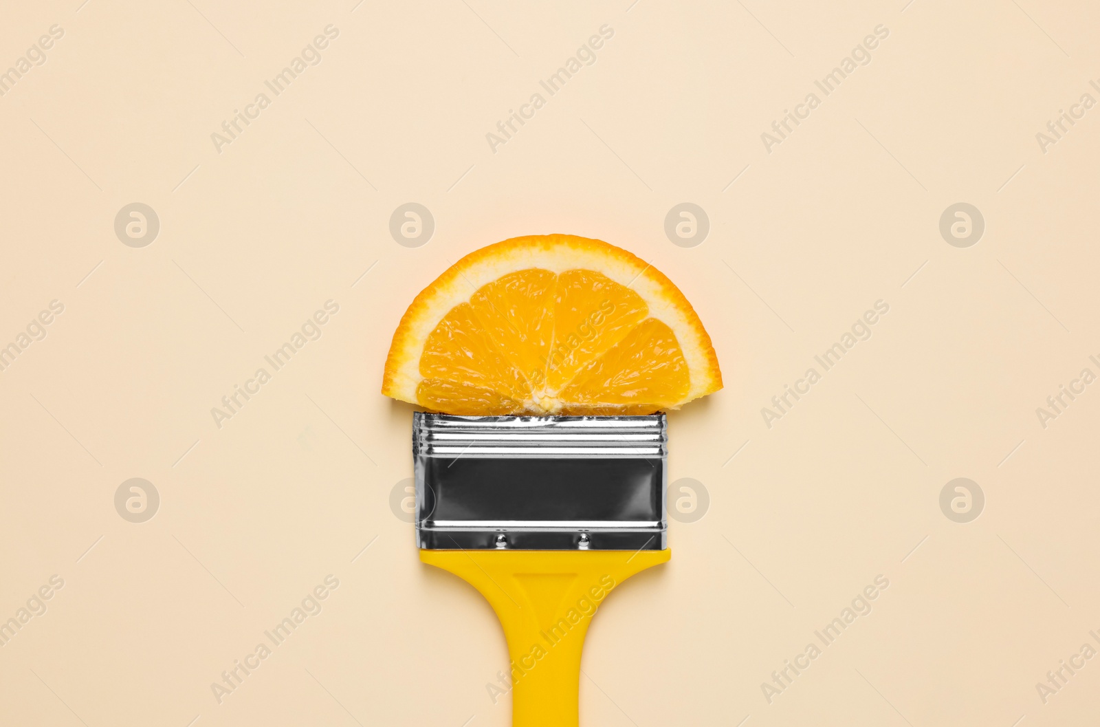 Photo of Creative flat lay composition with paint brush and orange slice on beige background