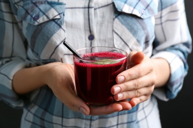 Photo of Woman with glass of fresh beet juice, closeup