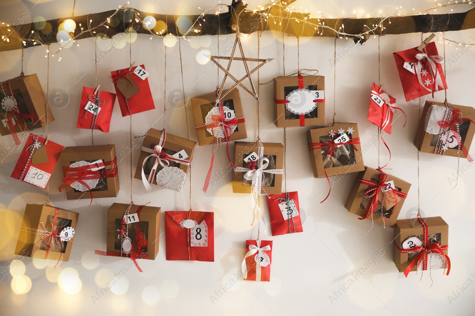 Image of Handmade Advent calendar with gifts hanging on white wall. Christmas season