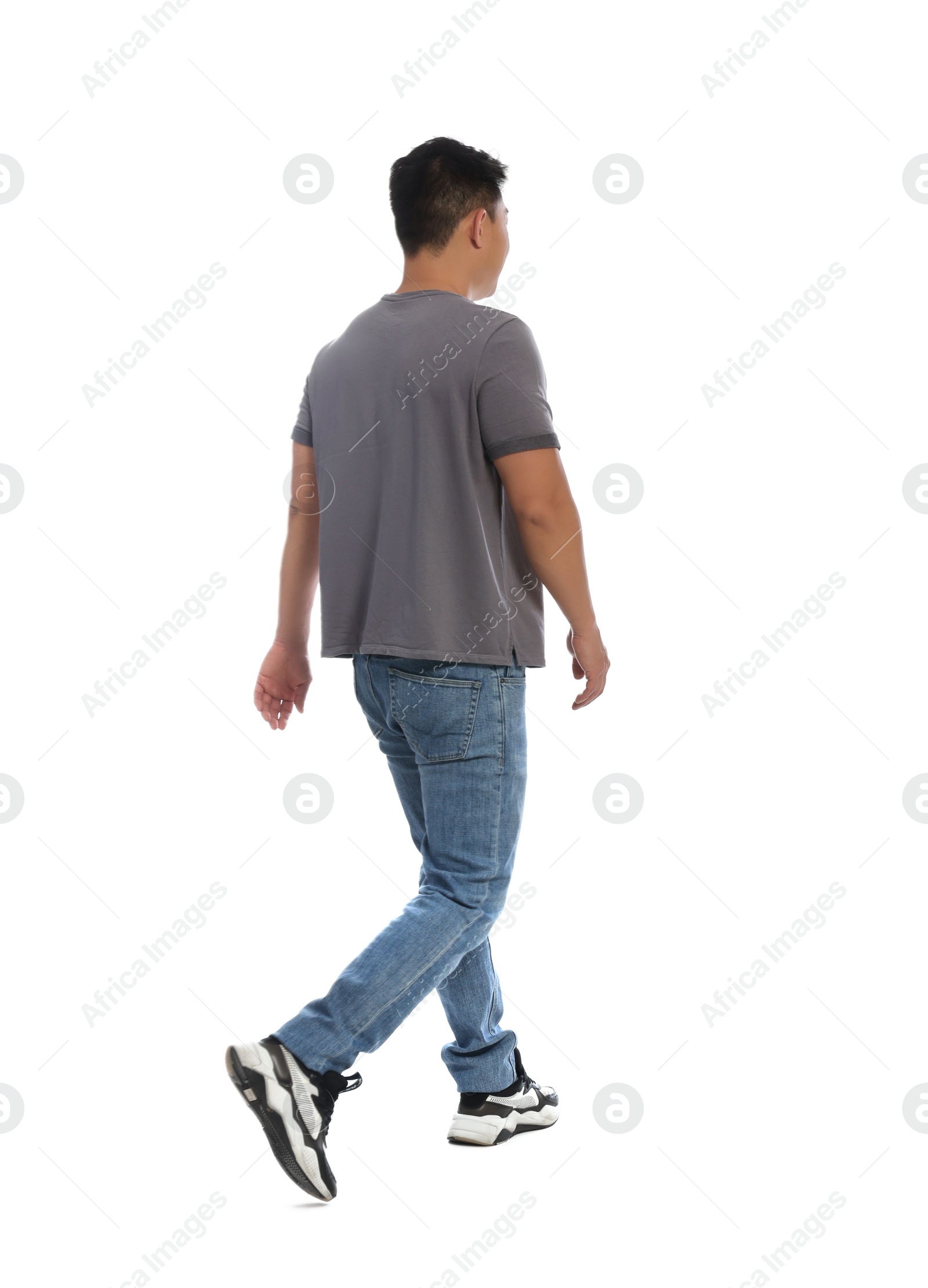 Photo of Man in casual outfit walking on white background, back view