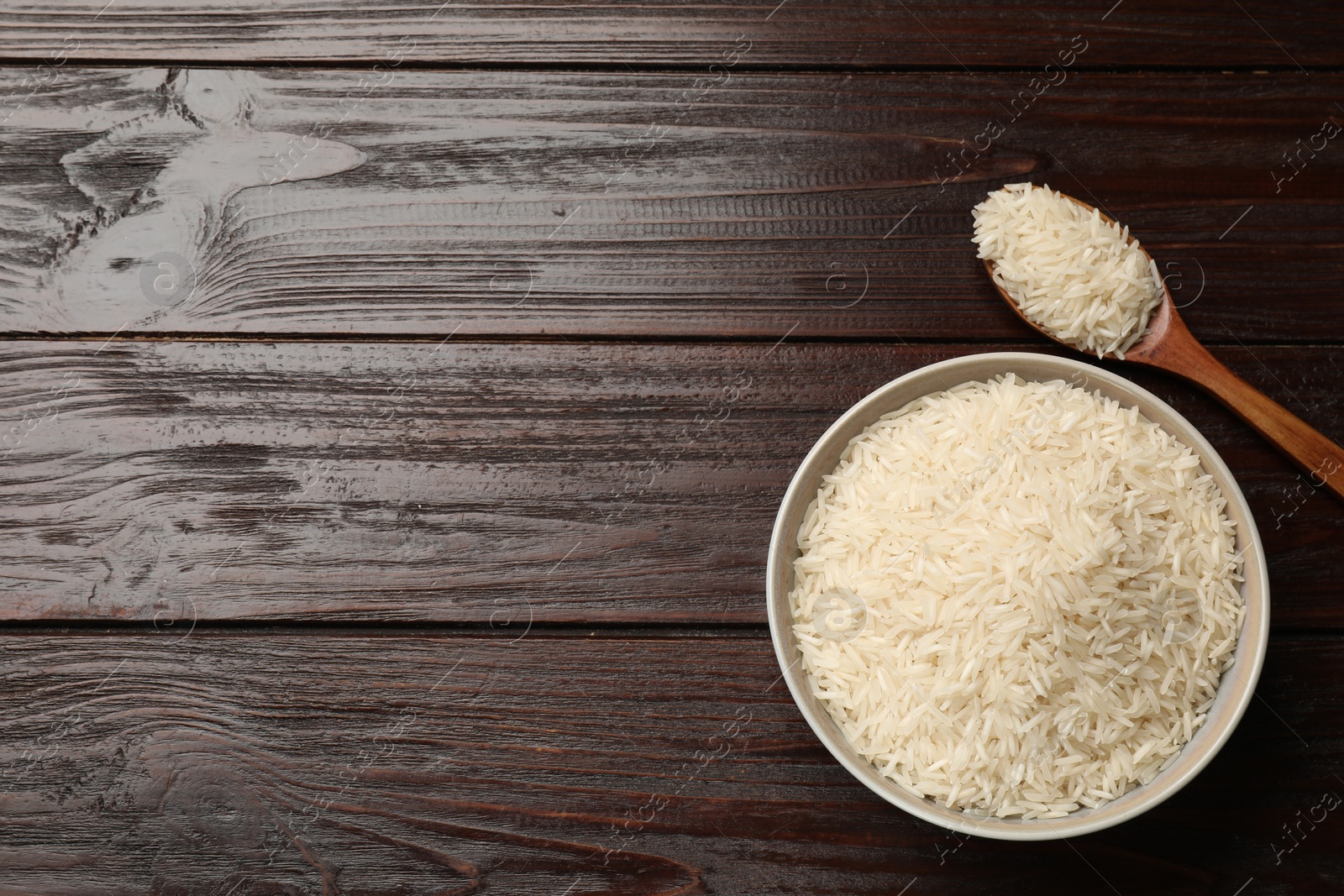 Photo of Raw basmati rice on wooden table, flat lay. Space for text