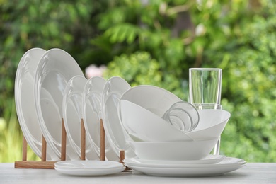 Set of clean dishware on table against blurred background