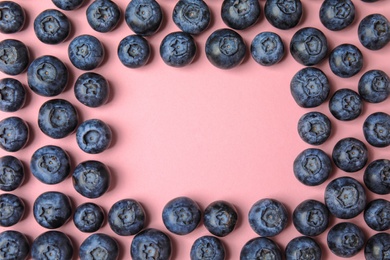 Photo of Frame of ripe blueberries on pink background, flat lay with space for text