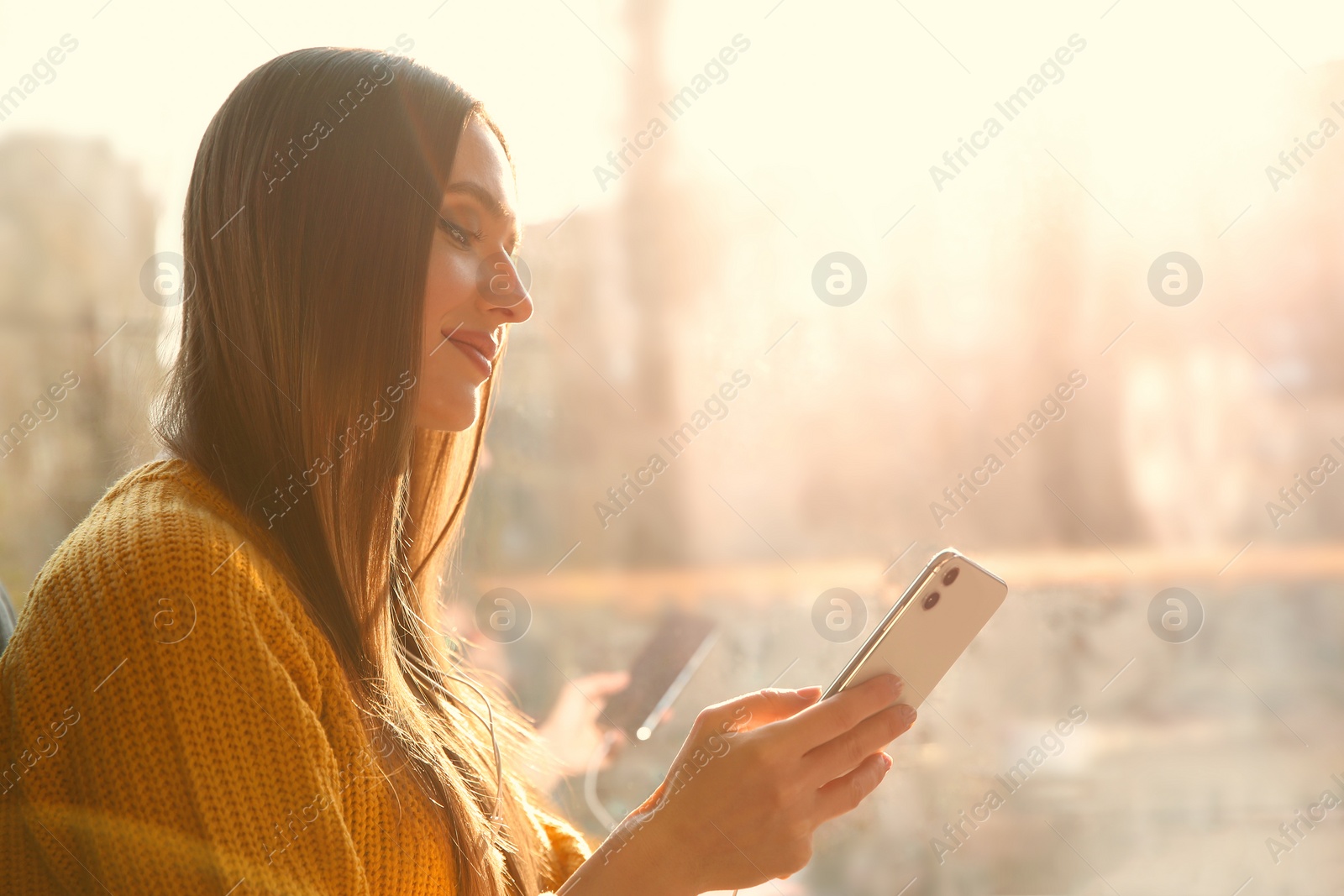 Photo of Woman listening to audiobook near window in cafe