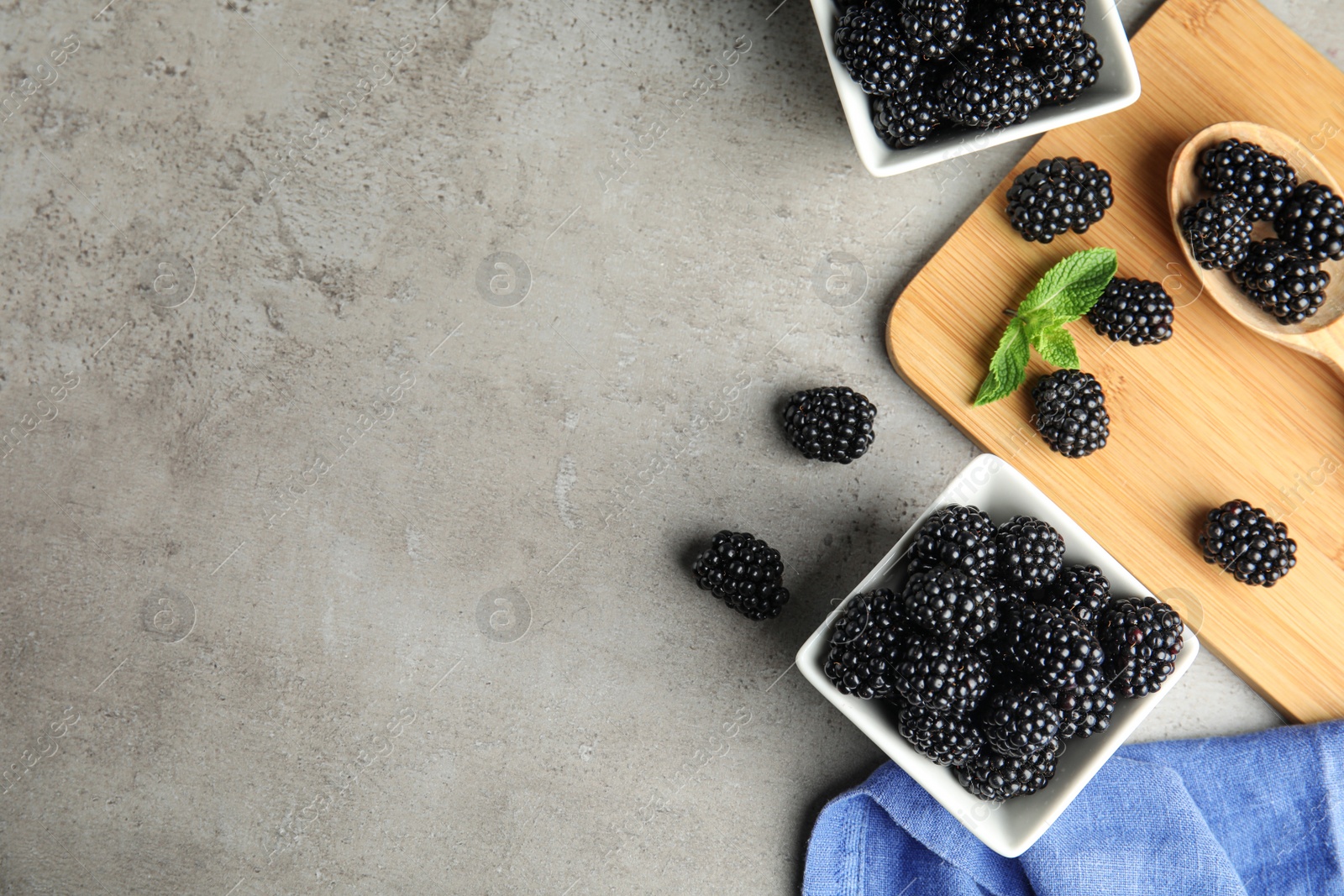 Photo of Flat lay composition with tasty blackberries and space for text on grey table