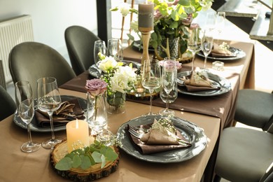 Photo of Festive table setting with beautiful tableware and floral decor in restaurant