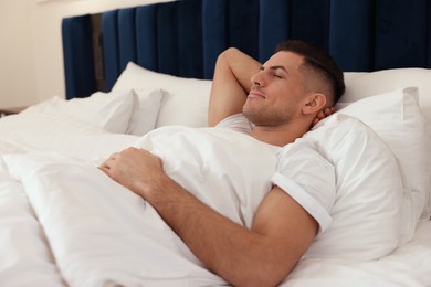 Photo of Handsome man sleeping in comfortable hotel bed
