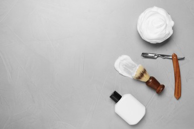 Set of men's shaving tools and foam on light gray table, flat lay. Space for text