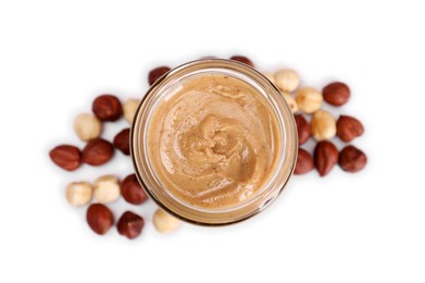 Photo of Tasty nut paste in jar and hazelnuts isolated on white, top view