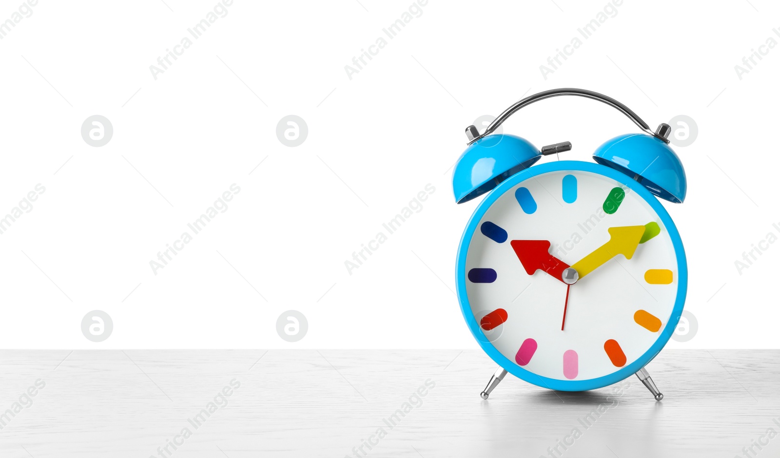 Photo of Alarm clock on table against white background. Time concept