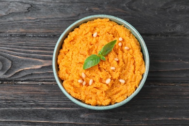 Bowl with mashed sweet potatoes on wooden table, top view