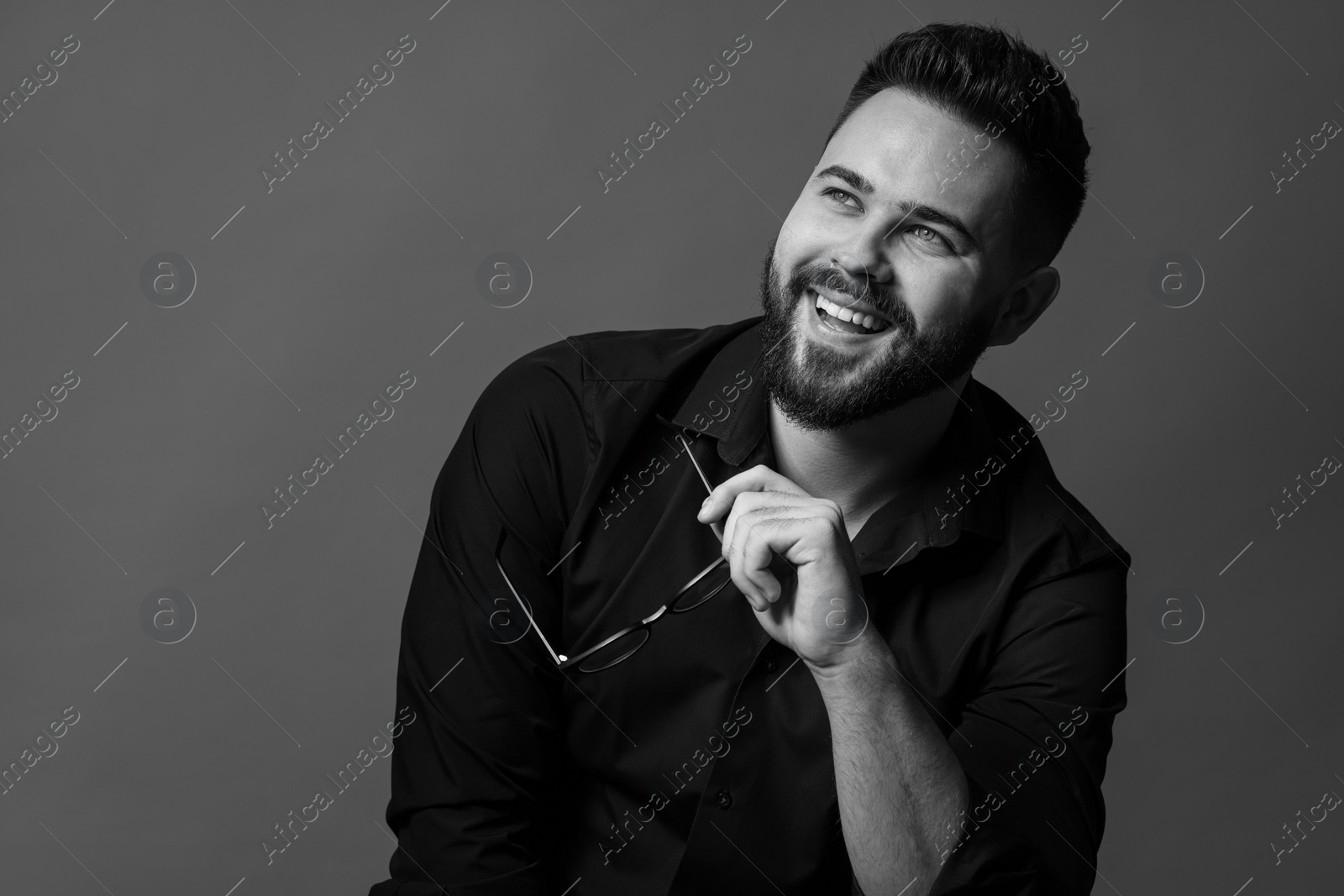 Photo of Portrait of handsome bearded man on grey background. Black and white effect