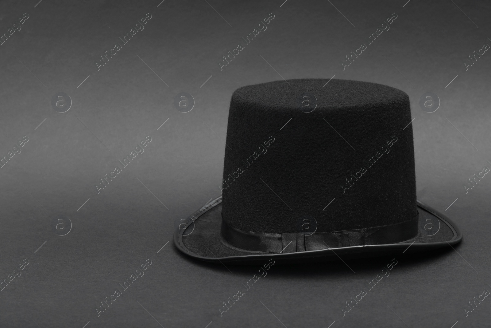 Photo of One magician top hat on dark grey background, space for text